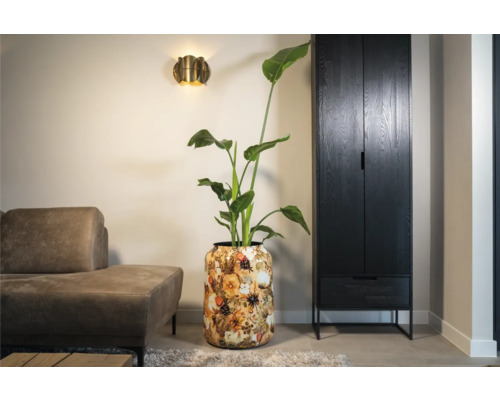 Woonkamer met plant in pot, bank, wandlamp en kast voor een lichte en georganiseerde sfeer