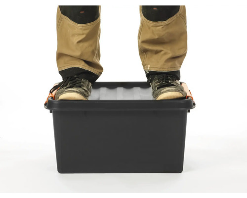 Persoon staat op een zwarte gereedschapskist.