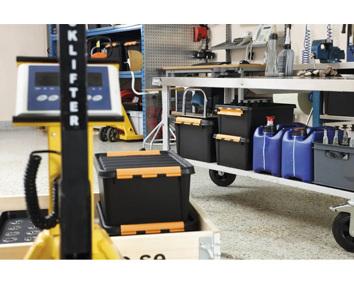 Werkplaats met gereedschapskisten, jerrycans en hefwagen