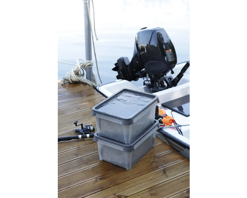 Twee transparante opbergdozen op een aanlegsteiger, naast een buitenboordmotor en een vishengel