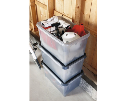 Drie transparante opbergdozen, gestapeld en gevuld met spullen