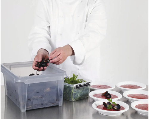 Een kok bereidt mosselen in een transparante opbergdoos en serveerdozen.