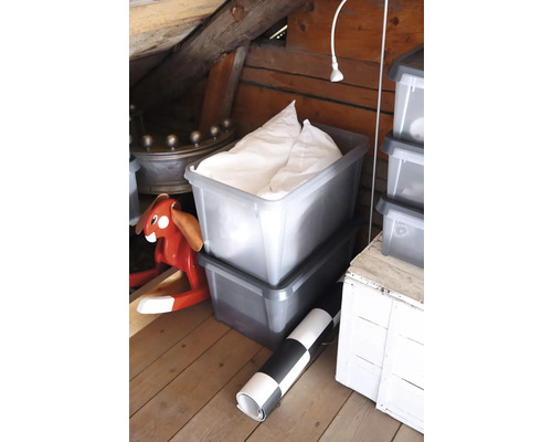 Twee grijze opbergdozen op zolder, de bovenste gevuld met textiel