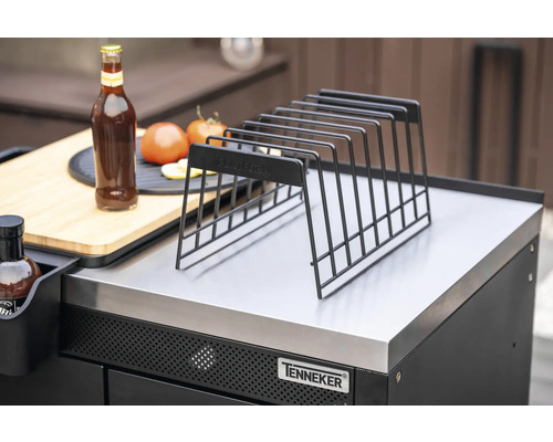 Metalen opbergrek op een grillstation met fles, tomaten en snijplank