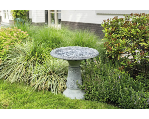 Decoratieve vogeldrinkbak van steen in de tuin