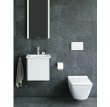 Moderne badkamer met wastafelonderkast, hangtoilet, spiegel en armaturen tegen een donkere muur