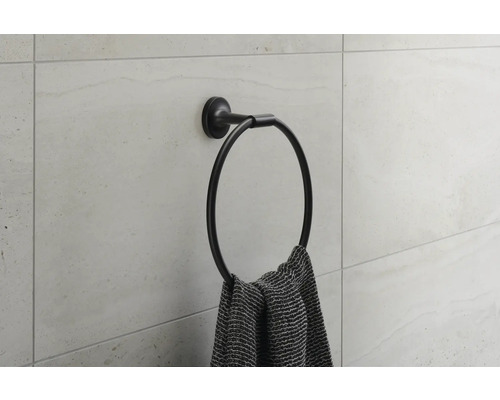 Ronde handdoekhouder aan een muur met een handdoek