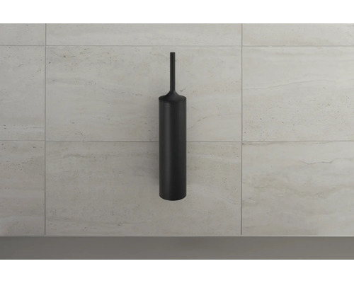 Zwarte toiletborstel tegen een betegelde muur