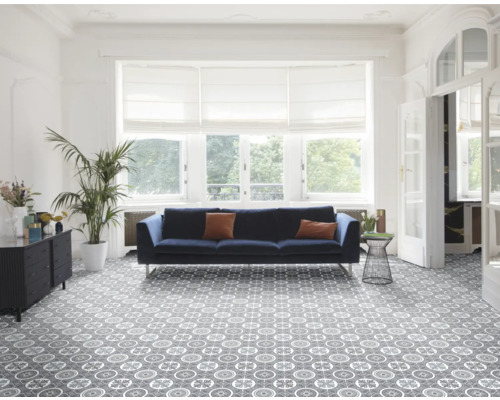 Lichte woonkamer met bank, plant en vinylvloer met patroon