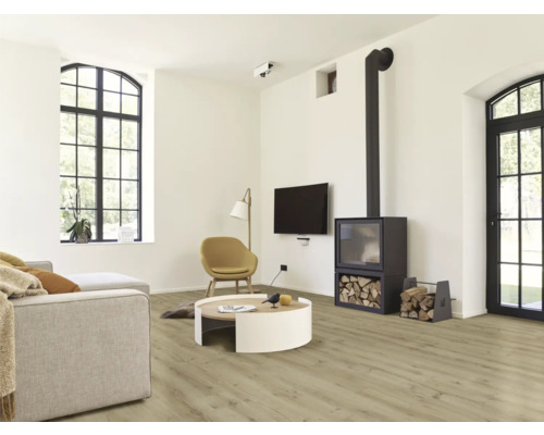 Lichte woonkamer met bank, fauteuil, houtkachel en houten vloer