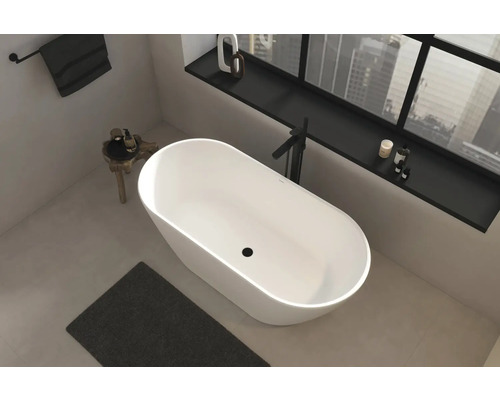 Vrijstaand bad in een heldere badkamer met raam