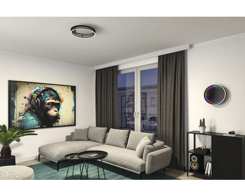 Lichte woonkamer met bank, salontafel, kast, kamerplant, plafondlamp en muurschildering