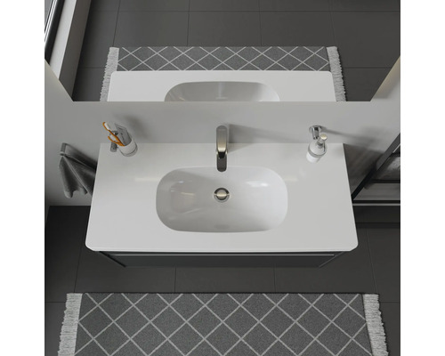 Bovenaanzicht van een badkamerwastafel met kraan en spiegel