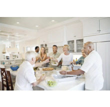 Lichte keuken met een groep mensen die samen eten en proosten