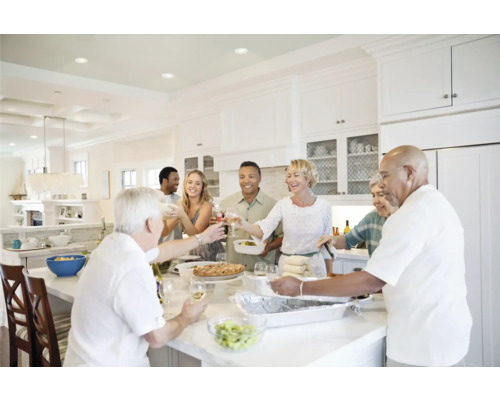 Lichte keuken met een groep mensen die samen eten en proosten