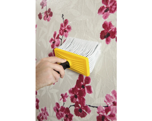 Behangborstel in gebruik op een bloemenbehang