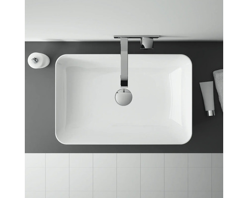 Bovenaanzicht van een badkamer met wastafel, kraan, zeepdispenser, handdoek en tegels