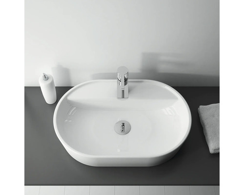 Bovenaanzicht van een wastafel met kraan, zeepdispenser en handdoek