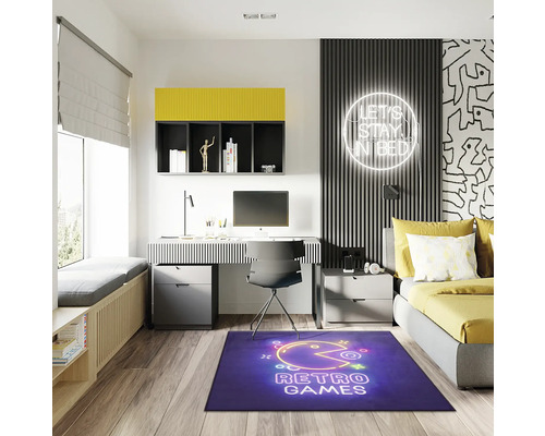 Moderne tienerkamer met bureau, bed en blauw tapijt met retro games motief.
