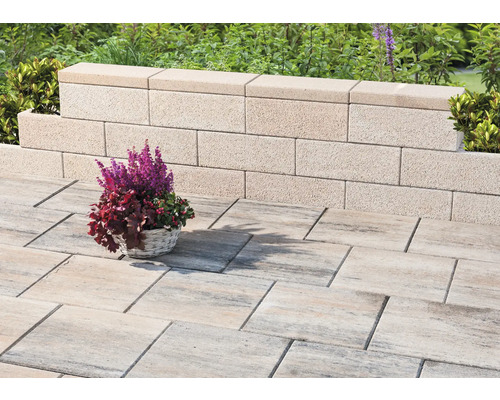 Tuinmuur van betonsteen met straatstenen en bloemenmand