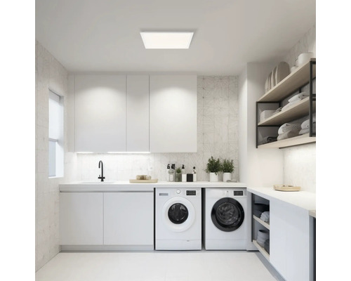 Lichte wasruimte met wasmachines, wastafel en plafondlamp