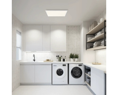 Lichte wasruimte met wasmachines, gootsteen, kasten en rekken