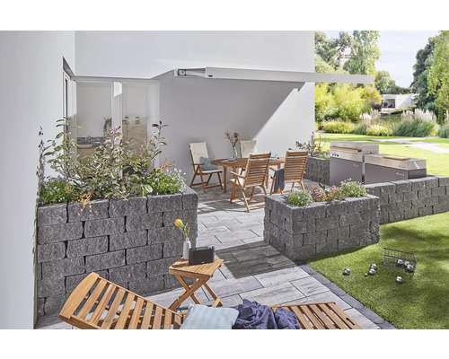 Terras met tuinmeubelen, barbecue en verhoogde stenen bloembedden