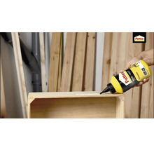 Houtlijm aanbrengen op een houten frame met een fles Pattex Houtlijm