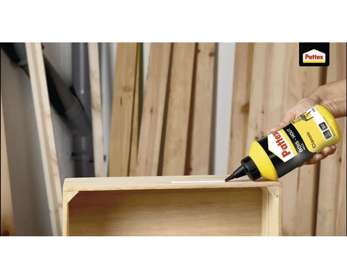 Houtlijm aanbrengen op een houten frame met een fles Pattex Houtlijm