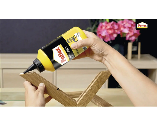 Een persoon brengt houtlijm van Pattex aan op een stuk hout