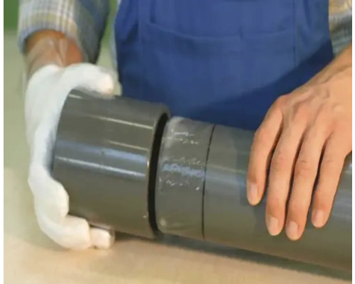 Persoon die een grijze kunststof buis verbindt