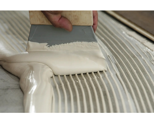 Lijm aanbrengen met een lijmkam op een oppervlak.