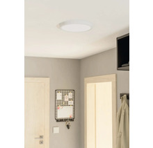 Plafondlamp in een kamer met een deur, een memobord en een kapstok