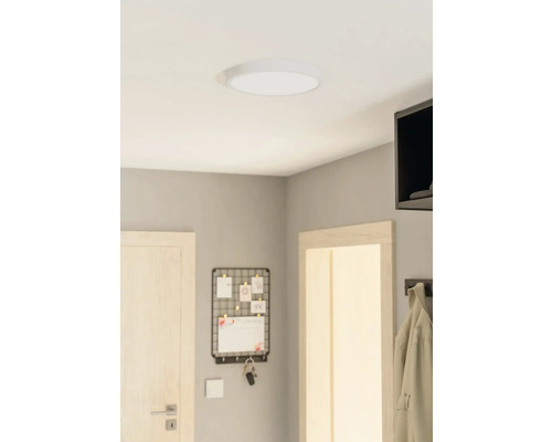 Plafondlamp in een kamer met een deur, een memobord en een kapstok