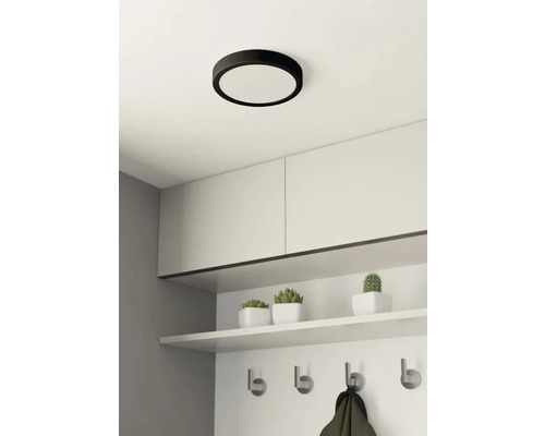 Ronde plafondlamp boven garderobe met haken en opbergruimte