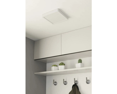 Vierkante plafondlamp in een kamer met planken en een kapstok.