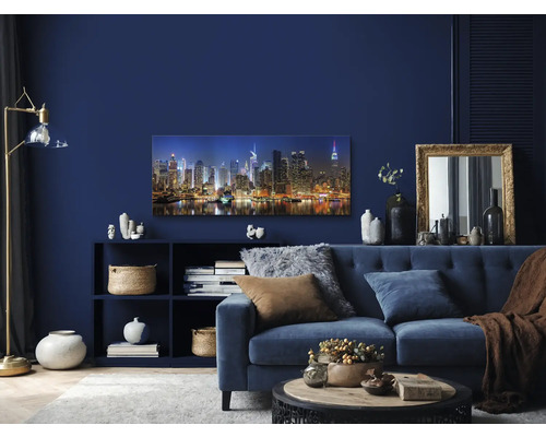 Woonkamer met blauwe bank, plank en New York Skyline muurschildering