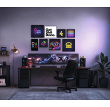 Gaming kamer met bureau, stoel, schermen en decoratieve muurkunst