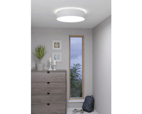 Plafondlamp in een lichte ruimte met dressoir en raam