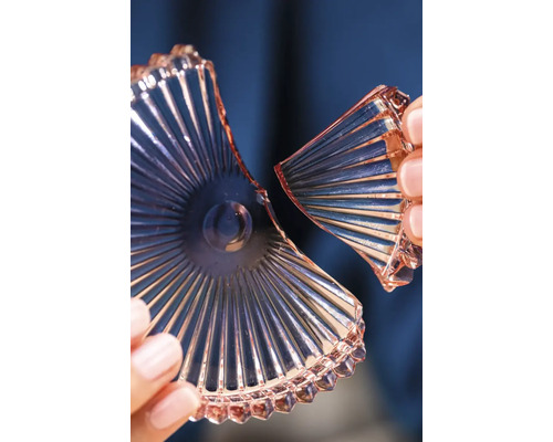 Gebroken glazen schaal met geribbeld patroon in handen.