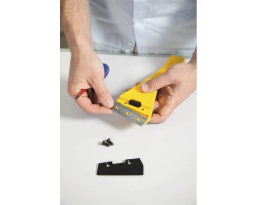 Behangperforator met gele handgreep en reservemes voor wandbewerking