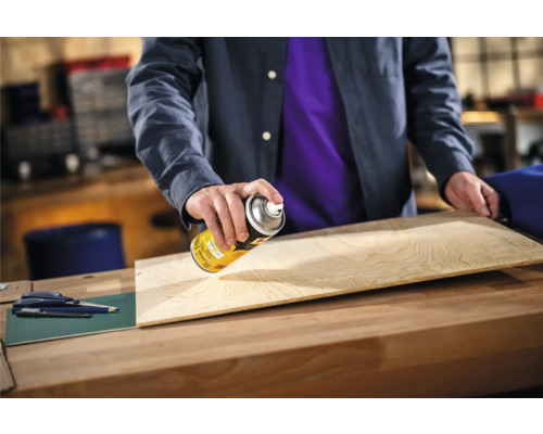 Persoon spuit lak op houten plank