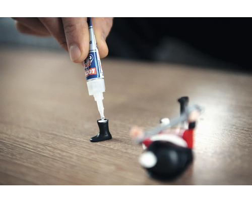 Secondenlijm wordt aangebracht op een stuk speelgoed.