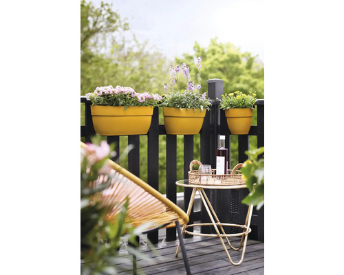 Buitenfoto van een balkon met bloembakken, stoel en tafel.