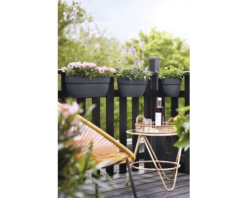 Balkonscène met bloembakken aan de reling, een klein tafeltje met drankjes en een stoel