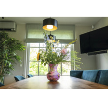 Eetkamer met houten tafel, bloemen in vaas en hanglampen
