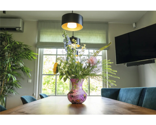 Eetkamer met houten tafel, bloemen in vaas en hanglampen