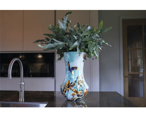 Decoratieve vaas met planten op een aanrecht