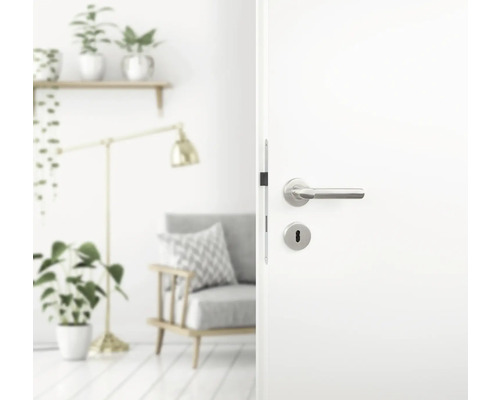 Geopende witte deur met zilverkleurige handgreep in een woonkamer.