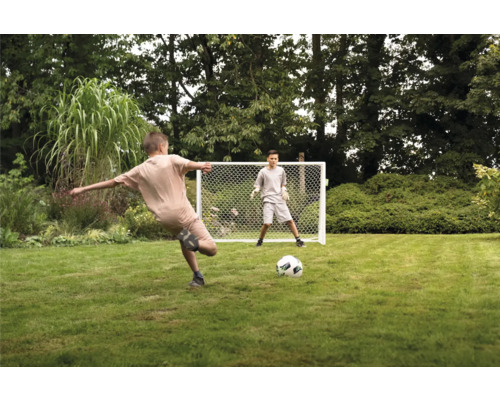 Twee jongens spelen met een voetbaldoel in de tuin.